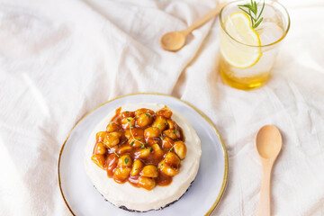 Caramel macadamia cheese pie and iced honey lemon soda with sunlight and shadow from a tree in...