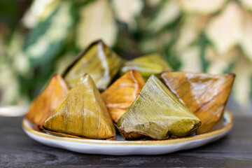 Stuffed dough pyramid thai dessert called Ka-Nhom-Tian. Desserts wrapped in banana leaves. Ka Nhom...