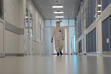 Almaty, Kazakhstan - 09.03.2021 : The doctor walks down the corridor, where the quartz lamp is turned on