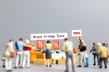 Miniature people , Shoppers with discount tray for shopping discounted items ,  Black Friday concept