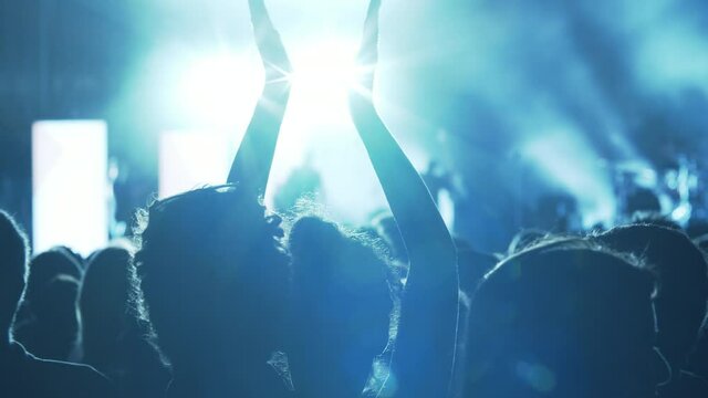 Slow motion shot of girl applauding among the crowd at the concert