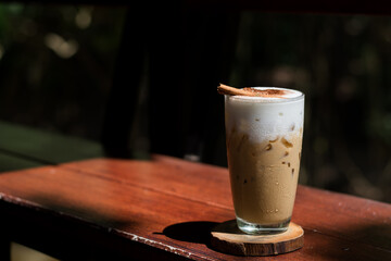 Coffee mugs are placed on a wooden coaster. And placed on a wooden floor and a dark background.