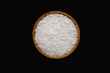 Wax resin on wooden plate. Beads wax pellets background. wax pallet isolated on black background. pe wax. lubricate wax.