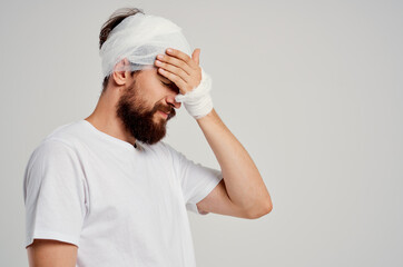 patient bandaged head and hand blood light background