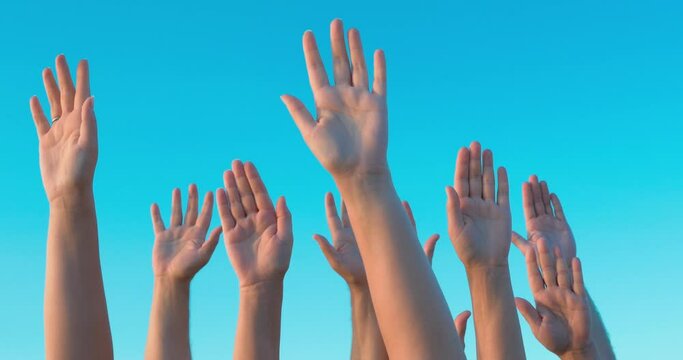 group of white people is raising hands up in the air clear blue sky is on the background