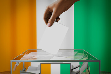 Cote d Ivoire flag, hand dropping ballot card into a box - voting, election concept - 3D illustration