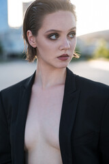 Stylish and attractive Caucasian girl in a suit posing on the street. Fashionable lady. Fashion concept