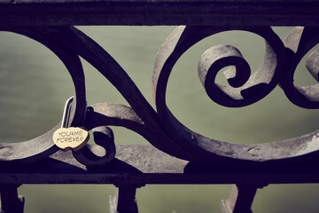 Padlock on a bridge inscribed with you and me forever