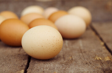 Colorful organic chicken eggs on wooden table. Natural and healthy food from village.