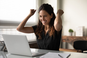 Happy excited millennial businesswoman in casual excited with good news at laptop, looking at...