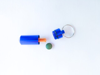 blue pill box with pills on white background