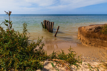 Deserted beach on the Black Sea coast. Wooden pegs to fishing boats.