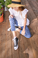 Girl on vacation hidden face by hat. Sitting unrecognised portrait. Female hipster cover face....