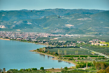 Nicea Iznik lake (iznik golu) with green plants and forest and way and signs of the road. Top and aerial view of famous and huge lake. During sunset and sun