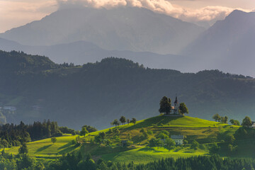 Landmark Church Stand Out at Hilltop in Julian Alps Landscape. Sveti Tomaz in Skofja Loka Slovenia