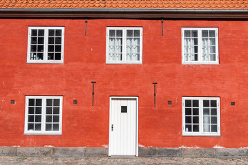 Fototapeta na wymiar White door and window on red brick wall of house building. Architecture background