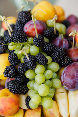 Dish with fruits and berries: grapes, blackberries, strawberries, peaches. wine snacks
