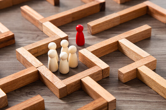 Wooden miniature at the start point of puzzle maze wood block. Leadership concept.