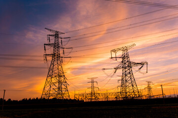 A silhouette of an electric tower against a beautiful sunset background