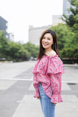 Portrait of young asian woman wearing stylish casual clothing and walking outdoor in city. Happy stylish woman with smiley face enjoys life