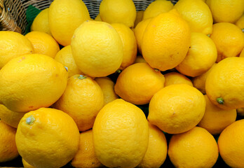 Colorful of yellow Display Of Lemons in a basket at bio market or grocery store. Organic Fresh lemons background close up.fresh lemons healthy vitamin C fruit