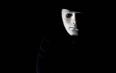 Anonymous careta blanca ojo con moneda de bitcoin con capucha y fondo negro. Hombre Anonymous careta blanca y moneda de bitcoin en lugar del ojo con capucha y fondo negro.