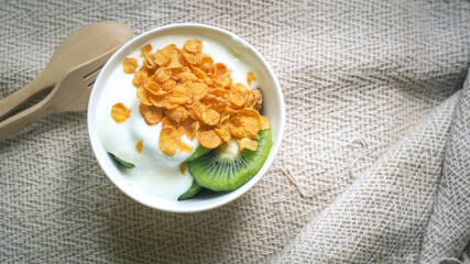 Corn flakes, cereal and milk splash in bowl . Natural homemade plain organic yogurt in wood bowl on wood texture background