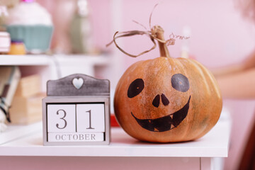 Wooden calendar show date 31 october halloween day and pumpkin on wooden school table in the girls...