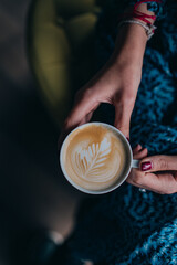 woman holding cup of coffee with latte art espresso