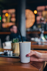 girl holding coffee latte in cafeteria