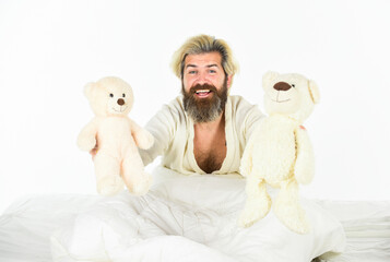 Good vibes. Playful and romantic. Man hug toy relaxing in bed. Imaginary friends. Strive to practice good sleep habits. Cute teddy bear toy. Positive bedroom environment. Bearded hipster play toy