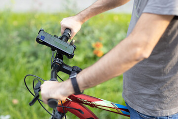 Man planning route using GPS navigation application in mobile phone on his bicycle bike