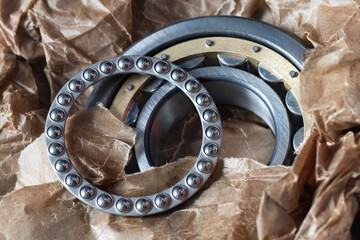 Large round bearing set for vehicle repairs. Close-up of new bearings in oiled wrapping paper.