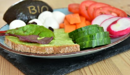 bio vegetables, avocado, radish, lettuce and tomatoes on a glass plate 