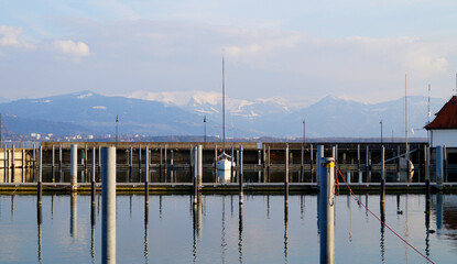 a beautiful marina of Lindau island on lake Constance with the Alps in the background on a sunny...