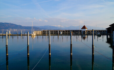 a beautiful marina of Lindau island on lake Constance with the Alps in the background on a sunny day in March