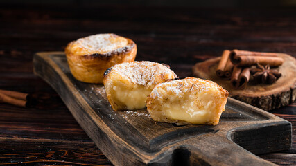 Pastel de Nata half cut, Traditional portuguese egg tart on wooden cutting board. Typical Portuguese custard pie