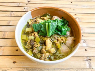 mie ayam (pangsit) or chicken noodle soup served in bowl.