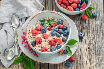 Healthy granola with milk and berries. Breakfast in summer garden.