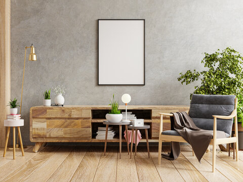 Poster mockup with vertical frame on empty dark concrete wall in living room interior with armchair.