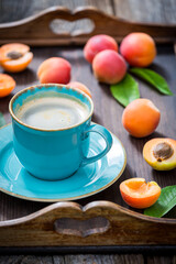 Obraz na płótnie Canvas Blue coffee and orange plums in sunny garden