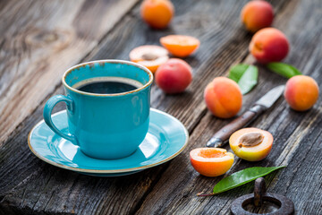 Blue coffee and orange plums on wooden table