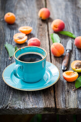 Fototapeta na wymiar Delicious coffee and plums on wooden table