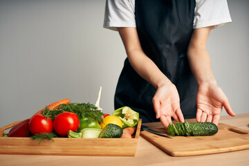 chef in black apron slicing vegetables kitchen close-up cooking