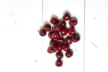 Sweet cherries on wooden background, closeup. Fresh ripe sweet cherries with droplets of water, top view