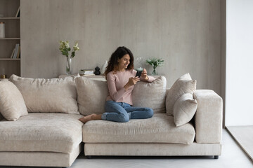 Full length addicted to modern technology beautiful happy young hispanic woman resting on...