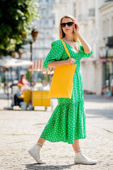 Young beautyful woman with yellow linen eco bag on city background.