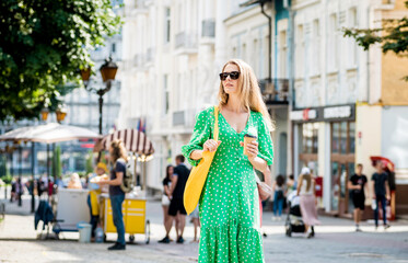 Young beautyful woman with yellow linen eco bag on city background.