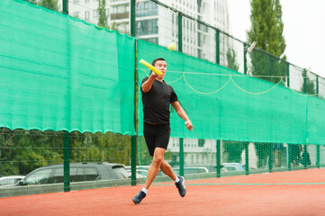 Fototapeta na wymiar A male tennis player is elegantly hitting a tennis ball. A tennis player who looks like a dancer.