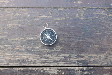 round compass on natural wooden background as symbol of tourism with compass, travel with compass...